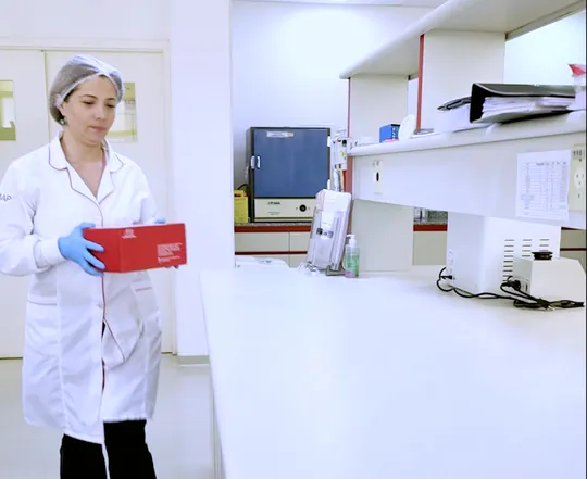 Analista carregando um kit da Intercientifica no laboratório